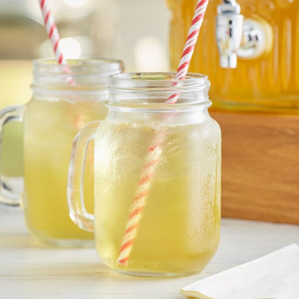 Two mason jars filled with Lipton iced tea with straws.