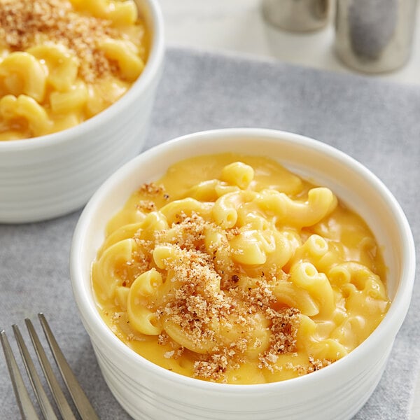 Two bowls of Knorr macaroni and cheese with a fork.