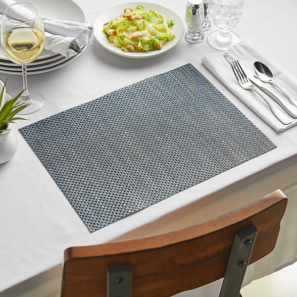 A table set with indigo basketweave rectangle placemats and silverware.