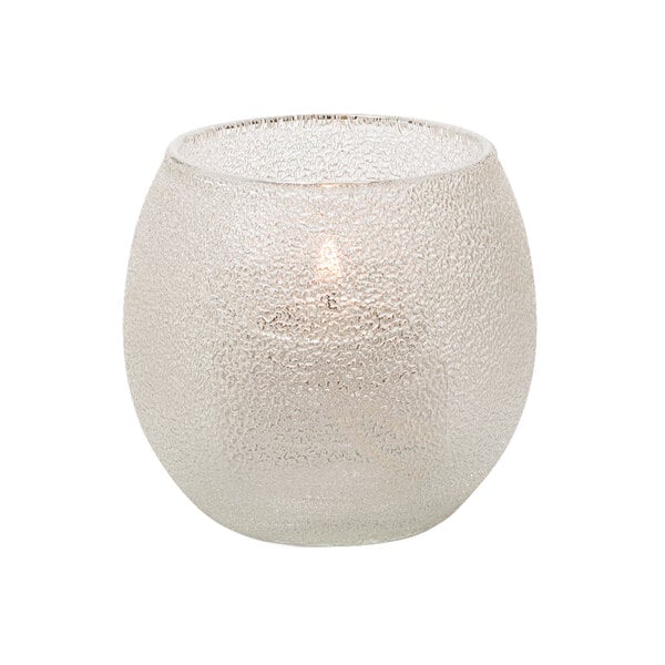 A small clear glass Hollowick tealight lamp with a lit candle.
