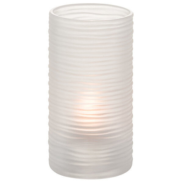 A clear glass cylinder candle holder with a lit candle inside.