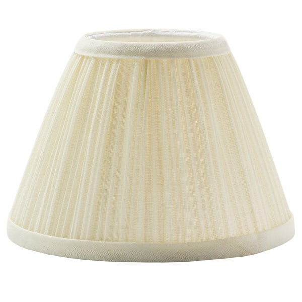A close up of a white fabric lamp shade with a pleated edge.