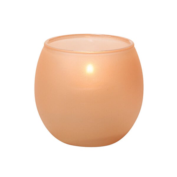 A small round Terra Cotta tealight holder with a lit orange candle inside.