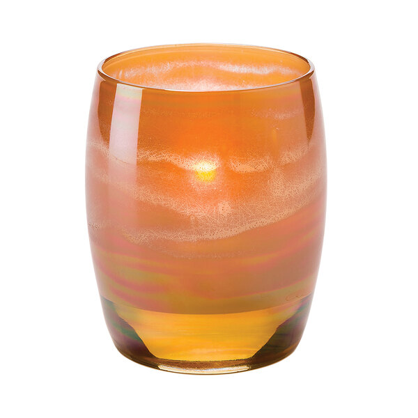 A Hollowick Contour Amber art glass votive with a lit candle inside, with orange and white swirls.
