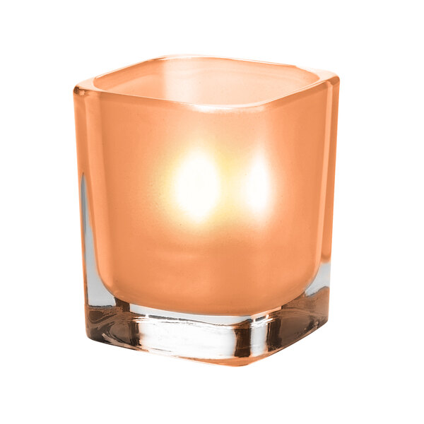 A small orange candle in a Terra Cotta glass square votive holder.