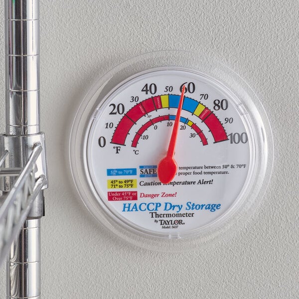 A Taylor 6" HACCP Prep / Dry Storage Wall Thermometer on a wall.