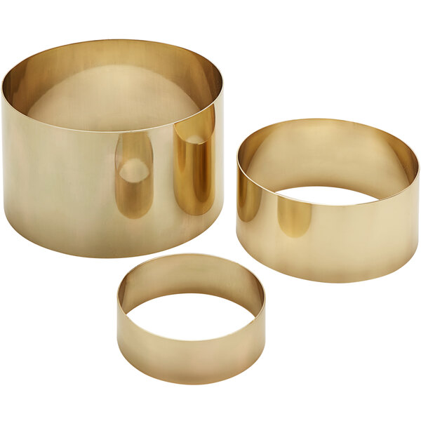 A group of gold cylindrical risers with a satin finish.