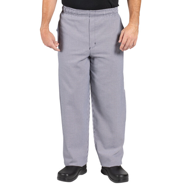 A man wearing Uncommon Chef houndstooth chef pants and a black shirt.