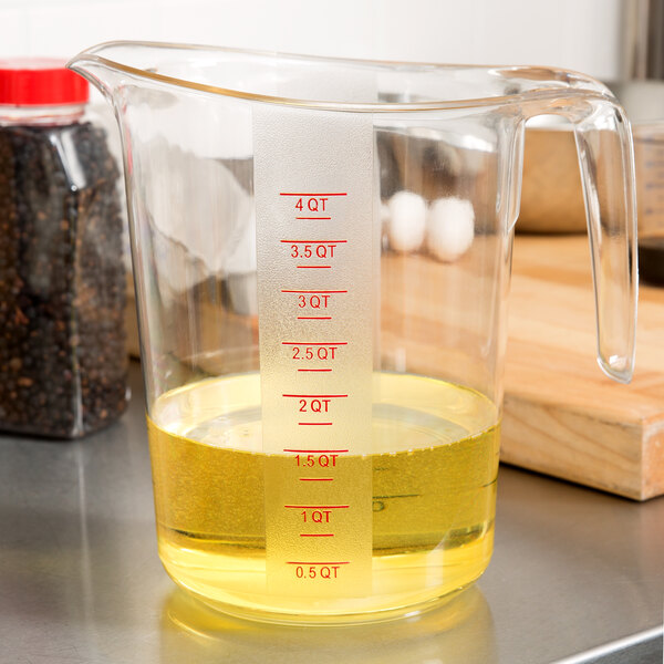 A Choice clear plastic measuring cup with yellow liquid inside.