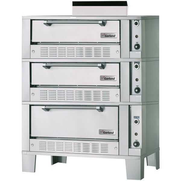 A large grey Garland triple deck oven with knobs.