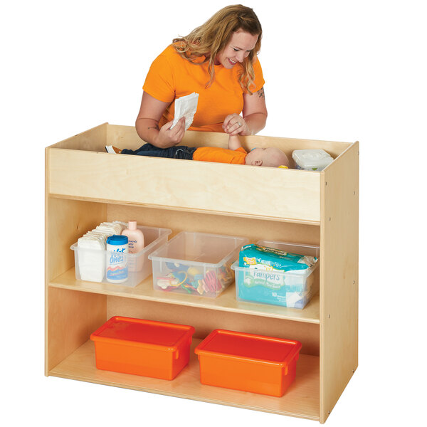 A woman changing a baby on a Young Time natural changing table.