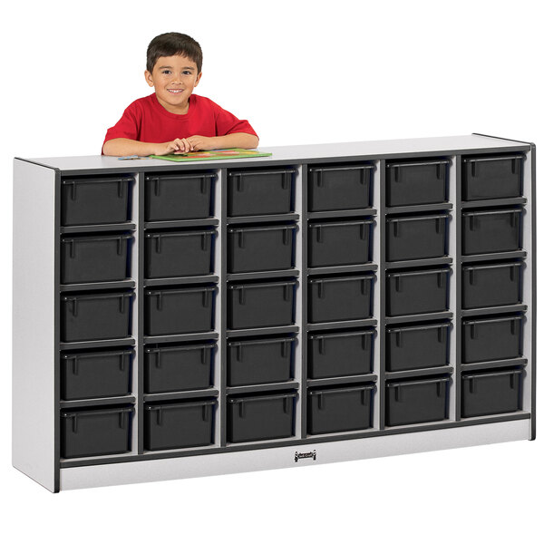 A young boy in a red shirt standing next to a black Rainbow Accents mobile storage cabinet.