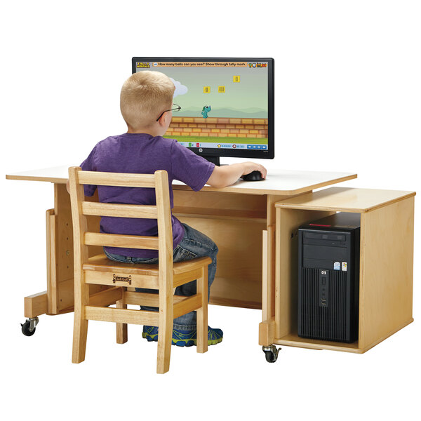 A child sitting at a Jonti-Craft computer desk with a white top using a computer.