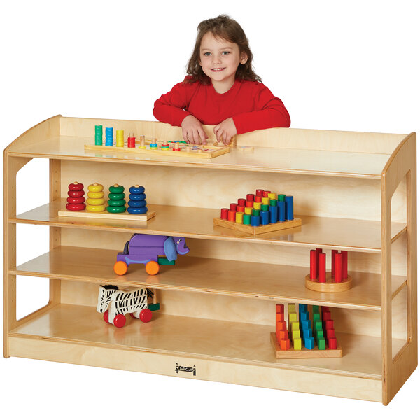 A young girl in a red shirt playing with Jonti-Craft wood storage shelves filled with toys.