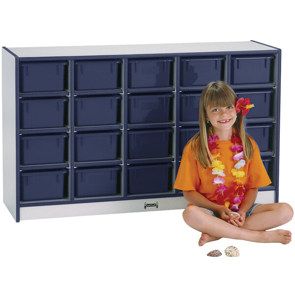 A young girl sitting in front of a Rainbow Accents navy and gray storage cabinet.