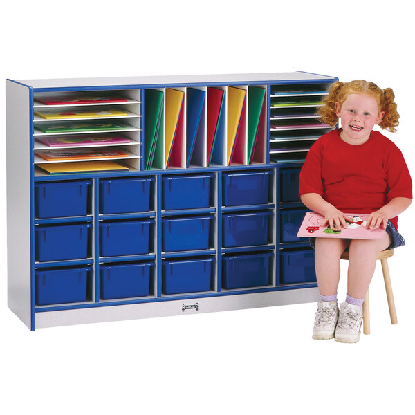 A girl sitting in front of a Rainbow Accents blue storage unit with blue trays.