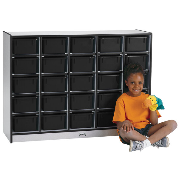 A young girl sitting next to a Rainbow Accents black laminate storage cabinet.