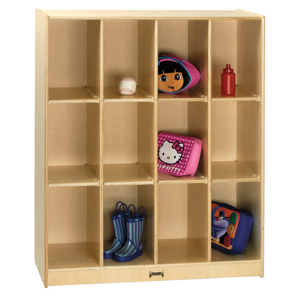 A Jonti-Craft wooden storage locker with 12 cubbies holding various toys and bags.