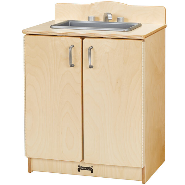 A Jonti-Craft wooden kitchen sink with cabinets on a counter.