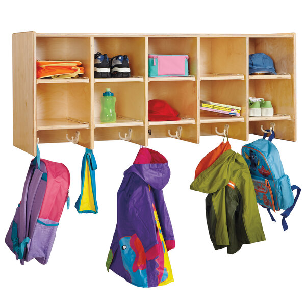 A Jonti-Craft wooden wall mount coat locker with cubbies holding coats and bags.