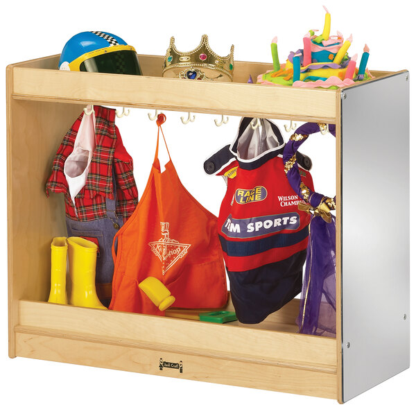 A Jonti-Craft wooden preschool dress-up island with toys and clothes on shelves.