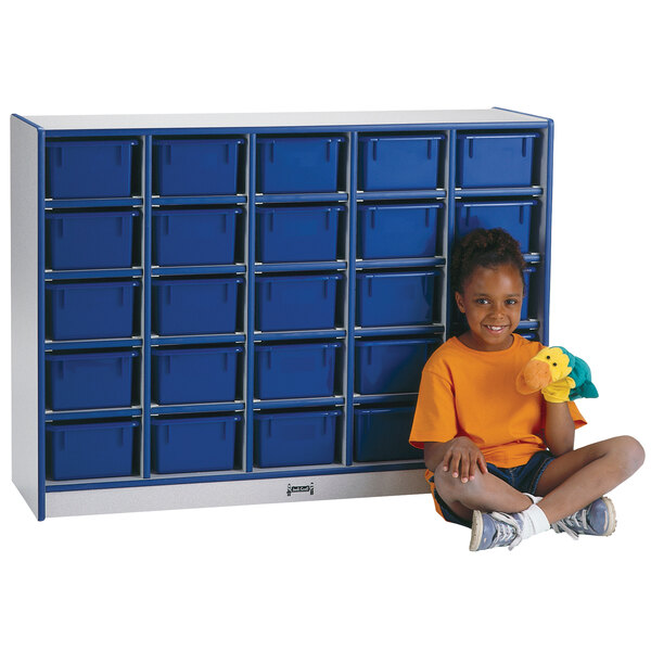 A young girl sitting next to a blue Rainbow Accents storage cabinet.