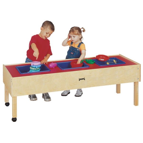 A boy and girl playing with toys in a Jonti-Craft toddler sensory table.
