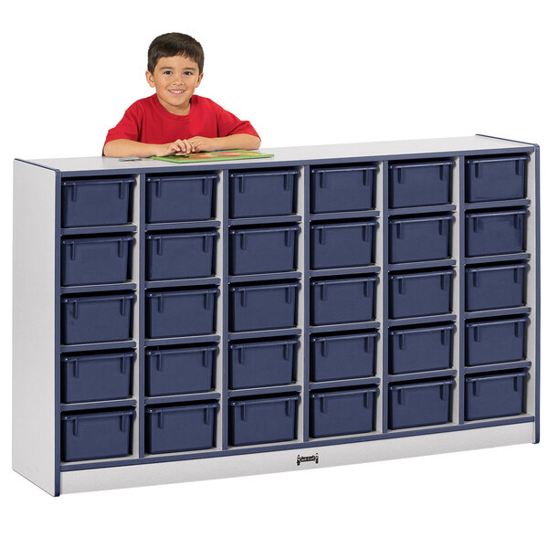 A young boy in a red shirt standing next to a Rainbow Accents navy and gray storage cabinet.