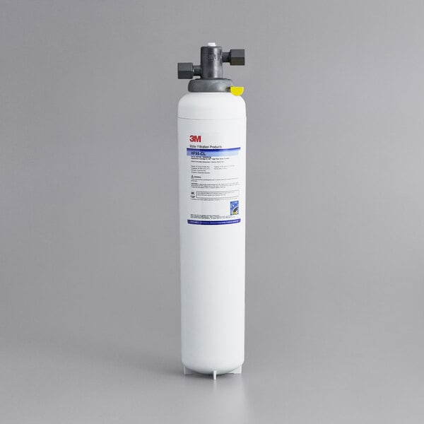 A white 3M water filtration system cylinder with black and blue text on it.