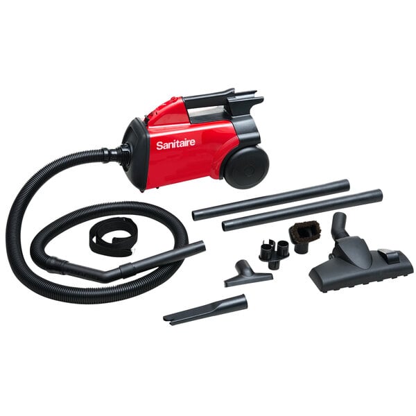 A red and black Sanitaire canister vacuum cleaner with hose and accessories.