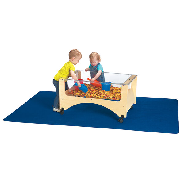 Two children playing with a Jonti-Craft sensory table on a wooden play table.