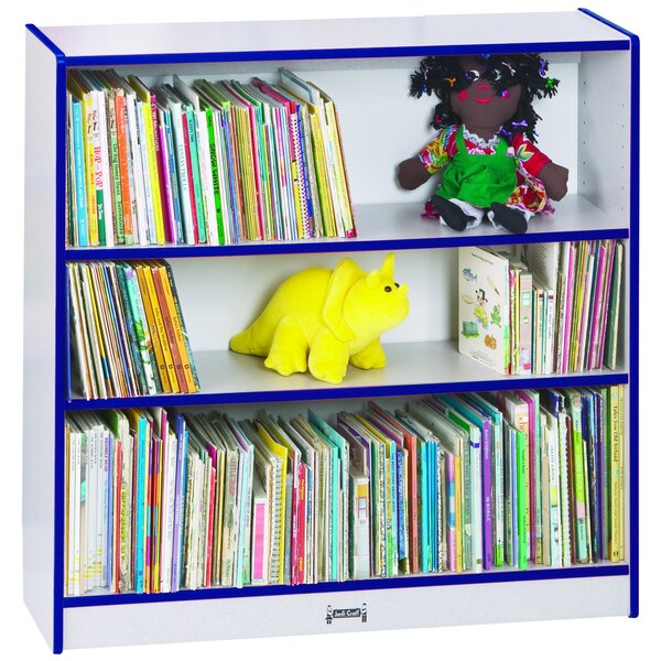A Rainbow Accents blue short bookcase with shelves of books and stuffed toys.