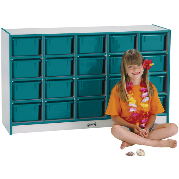 A young girl sitting in front of a blue Rainbow Accents storage cabinet.