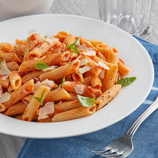 A plate of Costa Whole Grain Penne Rigate pasta with tomato sauce and parmesan cheese.