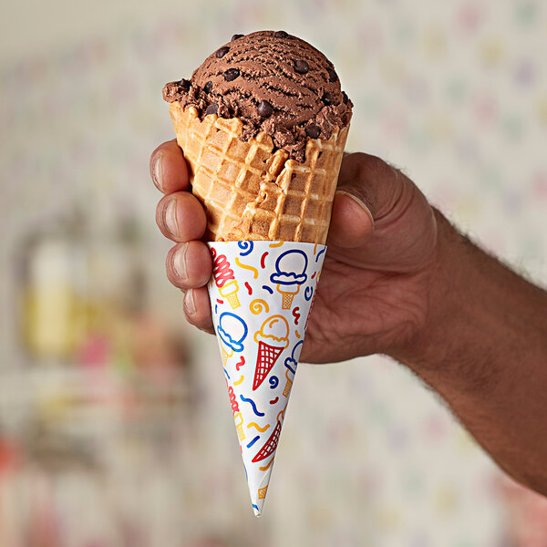 A hand holding a Keebler Colosso jacketed waffle cone filled with chocolate ice cream.