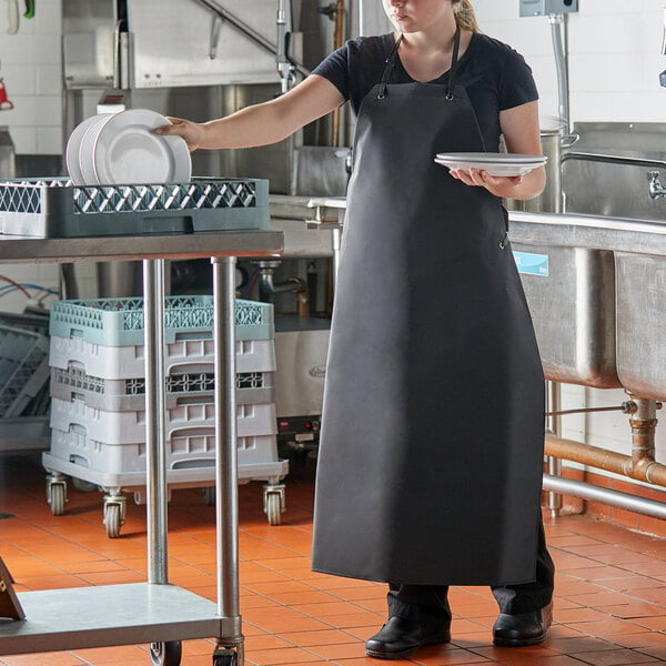 A woman in a black San Jamar Neo-Flex dishwasher apron standing at a counter.