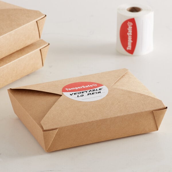 A brown box with a roll of red TamperSafe labels on a counter.