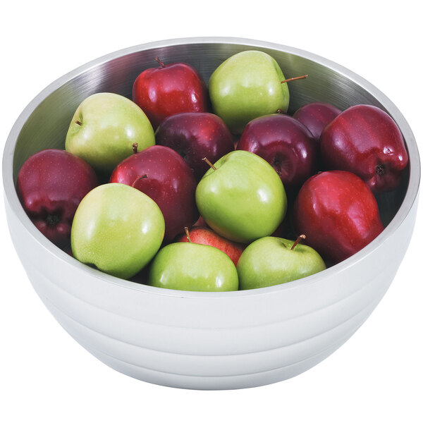 A Vollrath double wall metal serving bowl filled with red and green apples.