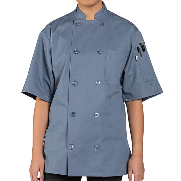 A person wearing a Uncommon Chef short sleeve chef coat with a customizable steel name tag.