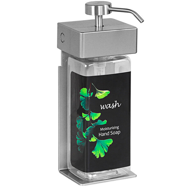 A white Dispenser Amenities wall-mounted shower dispenser with a black rectangular bottle and a black label with green leaves.