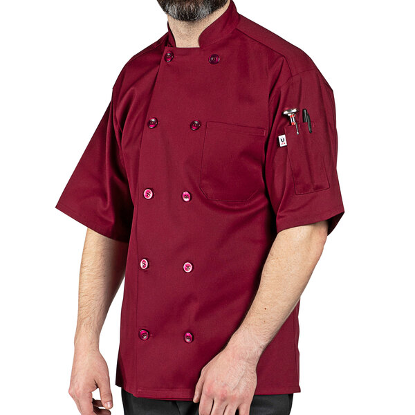 A man wearing a Uncommon Chef burgundy short sleeve chef coat.