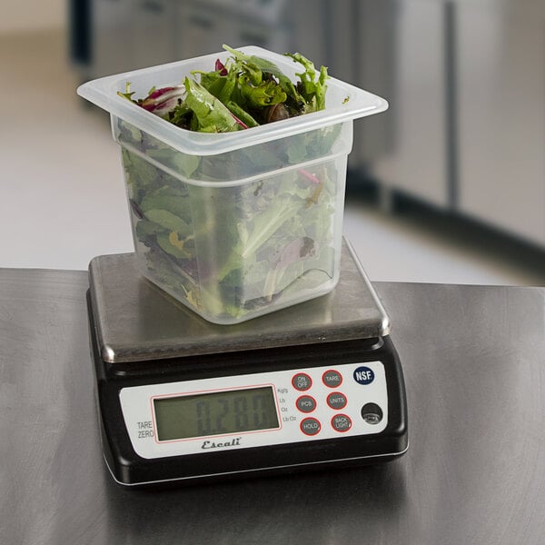 A plastic container of salad on a San Jamar digital portion scale.