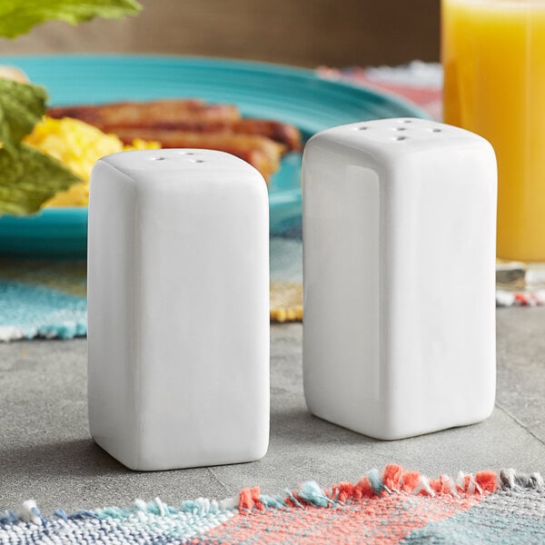 A set of American Metalcraft ceramic square salt and pepper shakers on a table.