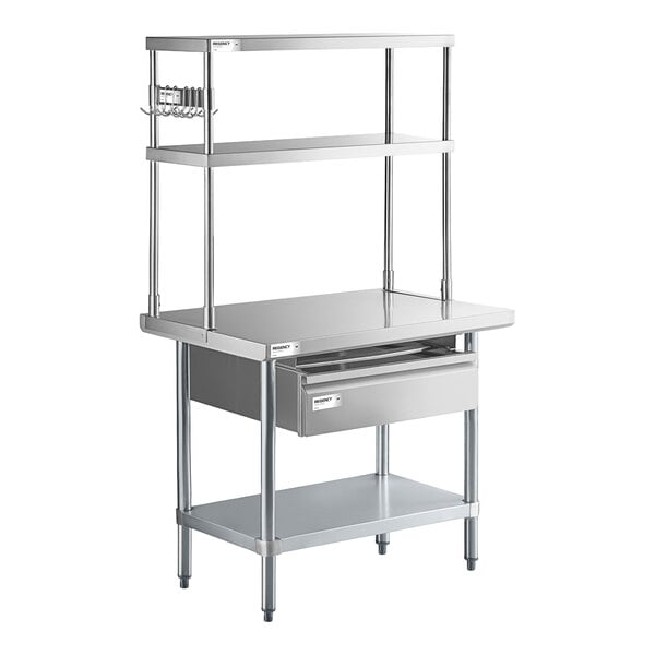 A stainless steel commercial work table with an undershelf, two upper shelves, a drawer, and a pot rack on the side.