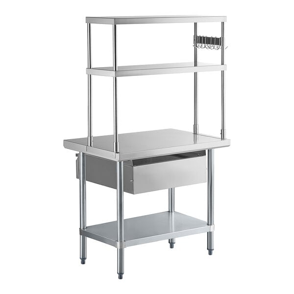 A stainless steel work table with an undershelf, two upper shelves, a drawer, and a small pot rack on the side.