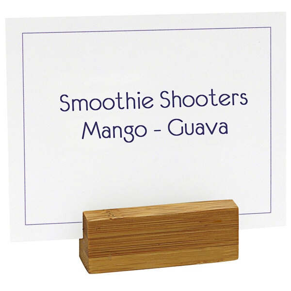 A white card in a Front of the House bamboo card holder with blue writing on it.