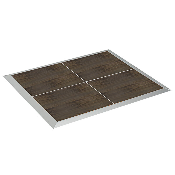 A dark walnut portable dance floor panel with silver trim on a square wooden surface.