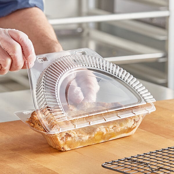 A person putting a pie in a Polar Pak clear plastic pie container.