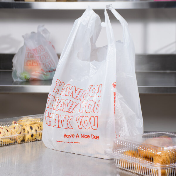 A 1/6 size white plastic T-shirt bag with "Thank You" in red text next to a plastic container of cookies.