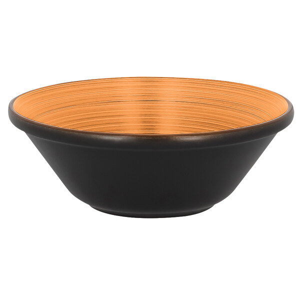 A black RAK Porcelain bowl with an orange rim on a table.